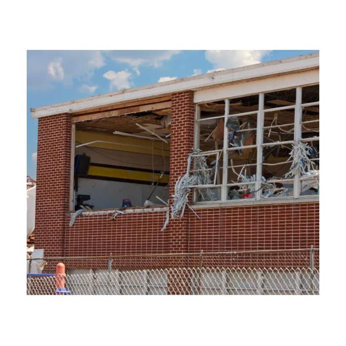 an image with an industrial builing missing windows from storm damage